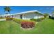 Low angle view of a bright home featuring neatly trimmed landscaping in a tranquil residential neighborhood at 6522 11Th W Ave, Bradenton, FL 34209