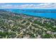 Expansive aerial view showcasing a residential neighborhood surrounded by lush trees and the beautiful blue waters of the bay at 1724 Harbor Dr, Clearwater, FL 33755