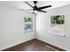 Bright bedroom features hardwood floors, two windows, and a ceiling fan at 1724 Harbor Dr, Clearwater, FL 33755