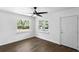 Bright bedroom featuring dark hardwood floors, white walls, and a modern ceiling fan at 1724 Harbor Dr, Clearwater, FL 33755