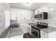 Bright, updated kitchen featuring granite countertops, stainless steel appliances, and white cabinets at 1724 Harbor Dr, Clearwater, FL 33755