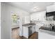 Modern kitchen with granite countertops, stainless steel appliances, and white cabinetry at 1724 Harbor Dr, Clearwater, FL 33755