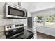 Modern kitchen with stainless steel appliances and a view of the yard through a window at 1724 Harbor Dr, Clearwater, FL 33755