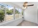 Bright sunroom featuring neutral tile flooring, ceiling fan and lots of natural light from large windows at 1724 Harbor Dr, Clearwater, FL 33755