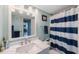 Well-lit bathroom featuring a marble vanity and a striped shower curtain for a fresh, clean design at 5501 80Th N St # 201, St Petersburg, FL 33709