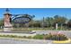 Welcoming entrance with brick sign, colorful flowers and lush landscaping at Avesa at 10096 Corso Milano Dr, Tampa, FL 33625