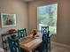 Charming dining area with rustic wooden table, colorful chairs, and a bright window offering outdoor views at 10096 Corso Milano Dr, Tampa, FL 33625
