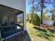 Exterior angle showcasing the screened porch and backyard landscape with mature trees at 10096 Corso Milano Dr, Tampa, FL 33625