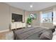 This staged bedroom features neutral colors, a ceiling fan, and an ensuite bathroom at 606 Riviera Dunes Way # 207, Palmetto, FL 34221