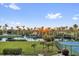 Beautiful community with lush landscaping, a lake with fountain and palm trees at sunset at 606 Riviera Dunes Way # 207, Palmetto, FL 34221