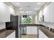 The kitchen features stainless steel appliances, granite countertops, and white cabinetry at 606 Riviera Dunes Way # 207, Palmetto, FL 34221
