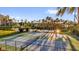 Outdoor tennis courts surrounded by lush greenery and palm trees at sunset at 606 Riviera Dunes Way # 207, Palmetto, FL 34221