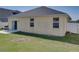 Home's backyard featuring lush green grass, a concrete patio, and a black peaked roofline at 3108 Magnolia Garden Dr, Plant City, FL 33567