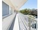 Long condo balcony with a white railing and view of trees at 2210 Utopian E Dr # 314, Clearwater, FL 33763