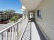 Long condo balcony with a white railing overlooking parking area and greenery at 2210 Utopian E Dr # 314, Clearwater, FL 33763
