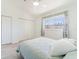 Bedroom with updated floors, white walls, closet, and a window with curtains at 2210 Utopian E Dr # 314, Clearwater, FL 33763