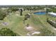 Expansive overhead shot of lush golf course fairways and a scenic pond surrounded by mature trees and greenery at 2210 Utopian E Dr # 314, Clearwater, FL 33763
