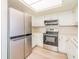 Kitchen with stainless steel appliances, white cabinetry, and a skylight for natural light at 2210 Utopian E Dr # 314, Clearwater, FL 33763