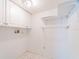 Clean, white laundry room with built-in shelving and tile flooring at 2210 Utopian E Dr # 314, Clearwater, FL 33763