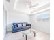 Sunlit living room with a modern ceiling fan, a comfortable blue sofa, and large windows at 2210 Utopian E Dr # 314, Clearwater, FL 33763