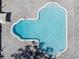 A high-angle shot shows a light blue kidney-shaped community pool bordered by light stone pavers at 2210 Utopian E Dr # 314, Clearwater, FL 33763
