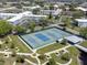 Overhead view of multiple community tennis courts surrounded by green areas with walkways, landscaping, and seating at 2210 Utopian E Dr # 314, Clearwater, FL 33763