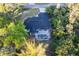 An aerial view shows a home with a screened in pool surrounded by lush trees and greenery at 2503 Dumont Ln, North Port, FL 34286