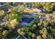 An aerial view showcases the home's screened pool and the surrounding neighborhood and lush greenery at 2503 Dumont Ln, North Port, FL 34286