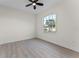 This bedroom features wood-look flooring, a ceiling fan, and a window with lots of natural light at 2503 Dumont Ln, North Port, FL 34286