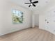 Bright bedroom featuring ceiling fan, hardwood flooring, large window, and a closet at 2503 Dumont Ln, North Port, FL 34286