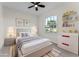 Staged bedroom with neutral tones, soft rug, decorative shelving, and a bright window enhancing the cozy ambiance at 2503 Dumont Ln, North Port, FL 34286