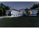 Charming home at night with well-manicured lawn, elegant lighting, and welcoming curb appeal under a starry sky at 2503 Dumont Ln, North Port, FL 34286