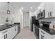 Modern kitchen with black countertops, white cabinets, stainless steel appliances, and a neutral color scheme at 2503 Dumont Ln, North Port, FL 34286