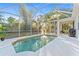 Inviting pool area with screen enclosure and lush greenery, ideal for outdoor relaxation and entertaining at 2503 Dumont Ln, North Port, FL 34286