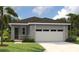 Charming single-story home with stone accents, a well-manicured lawn and a two-car garage at 6022 Jensen View Ave, Apollo Beach, FL 33572