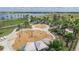 Aerial view of a splash pad with water features, surrounded by palm trees, a lake, and walking paths at 6022 Jensen View Ave, Apollo Beach, FL 33572