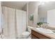 Cozy bathroom features a shower with a curtain, a granite sink, and tastefully decorated with art and a plant at 2723 Jollivette Rd, North Port, FL 34288