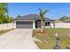 Charming one-story home featuring a well-manicured lawn, attached two-car garage and a lovely palm tree at 2723 Jollivette Rd, North Port, FL 34288
