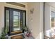The home features a stylish black front door with glass inserts, modern lighting, and beautiful potted plants at 2723 Jollivette Rd, North Port, FL 34288