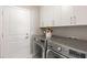 Laundry room with modern washer and dryer, white cabinets and gold hardware for a clean and efficient space at 2723 Jollivette Rd, North Port, FL 34288