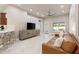 Bright living room showcasing a large ceiling fan, TV, and access to the kitchen at 2723 Jollivette Rd, North Port, FL 34288