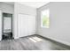 Bedroom featuring neutral walls, sleek floors, a closet, and a window overlooking the backyard at 17041 Malta Ave, Port Charlotte, FL 33954