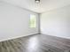 Bright bedroom featuring wood-look floors and a window letting in natural light at 17041 Malta Ave, Port Charlotte, FL 33954