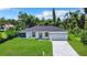 Picture-perfect single-Gathering home featuring lush green lawn, and modern gray driveway and exterior accents at 17041 Malta Ave, Port Charlotte, FL 33954