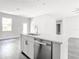 Contemporary kitchen island with a stainless steel dishwasher, white countertops, and sleek dark hardware at 17041 Malta Ave, Port Charlotte, FL 33954
