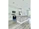 A modern kitchen with stainless steel appliances, an island, and white cabinetry at 17041 Malta Ave, Port Charlotte, FL 33954