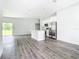 Open-concept kitchen featuring stainless steel appliances, a modern island, and sleek gray flooring at 17041 Malta Ave, Port Charlotte, FL 33954