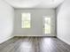 Bright living room with neutral walls and stunning wood-look flooring, enhanced by natural light at 17041 Malta Ave, Port Charlotte, FL 33954