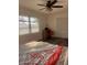 Bright bedroom with a ceiling fan, a desk near the window and a bed with red accents at 355 Highland Shores Dr, Ellenton, FL 34222