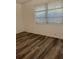 A bedroom with wood-look floors and a bright window with blinds at 355 Highland Shores Dr, Ellenton, FL 34222
